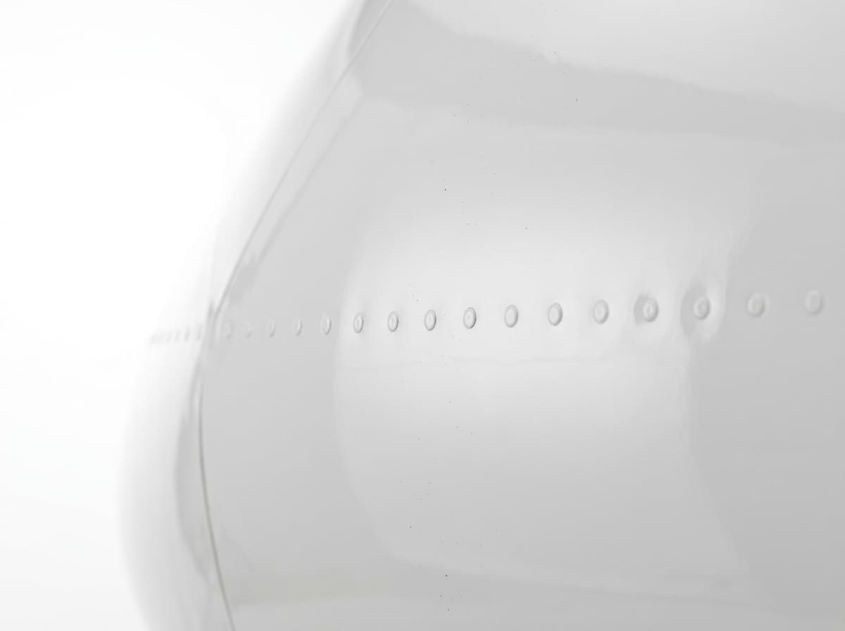 Mirror-finish reflection on flawless white private jet fuselage panel