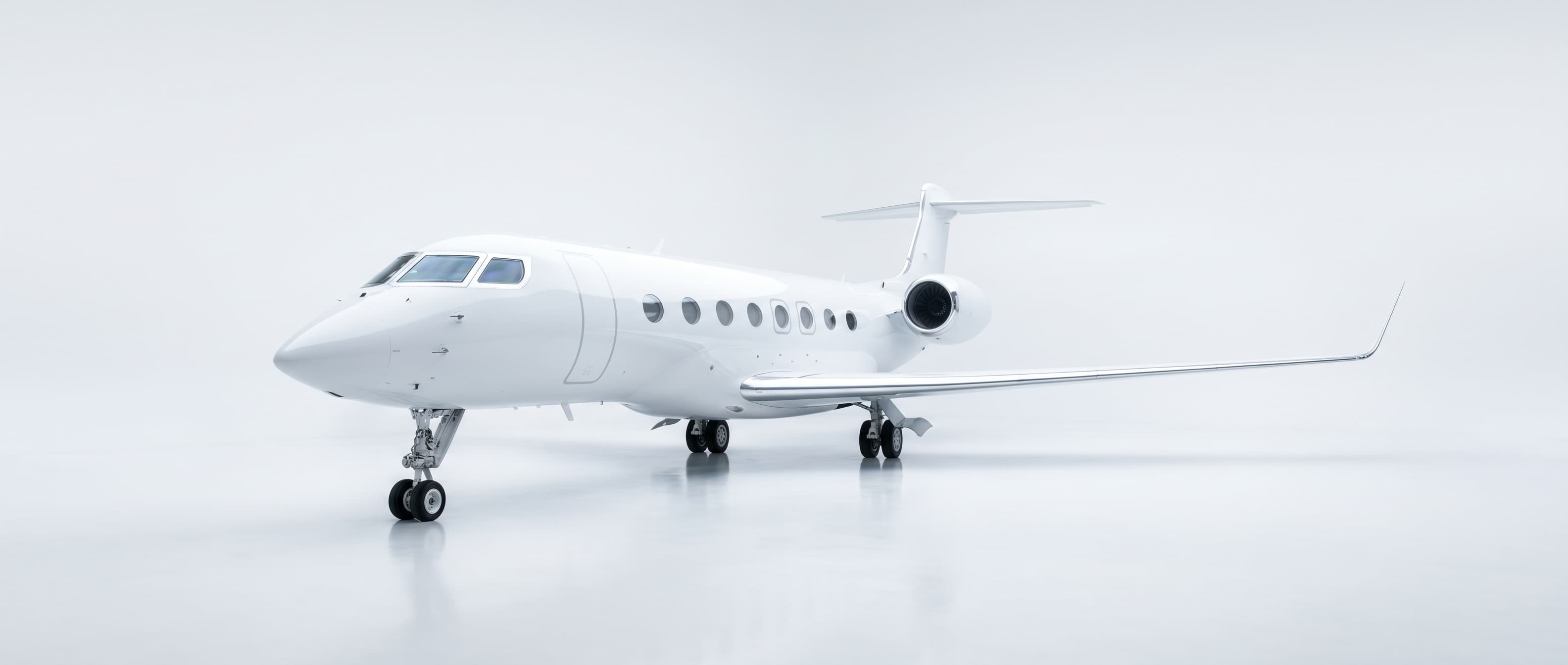 Glossy white private jet photographed in a clean white studio environment