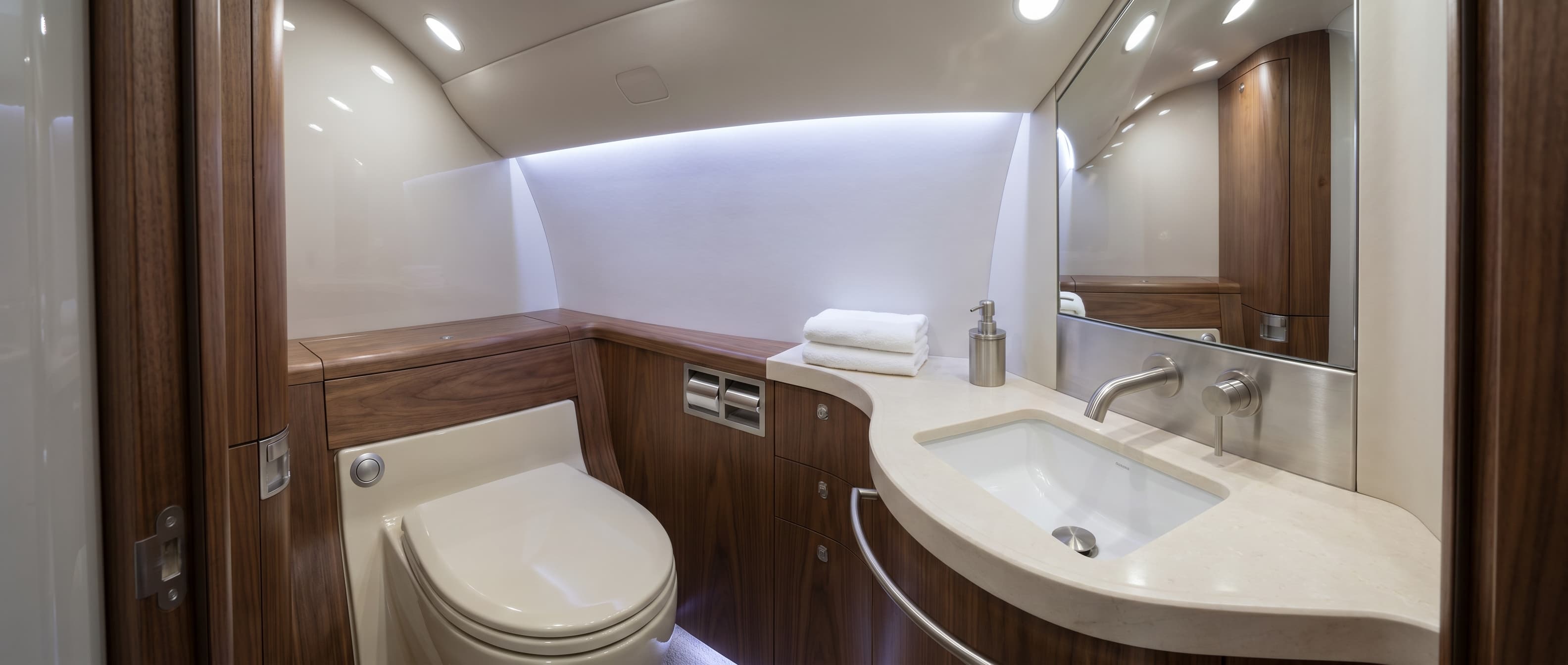 Polished aircraft lavatory after deep detail — toilet, basin, mirror, and trim gleaming